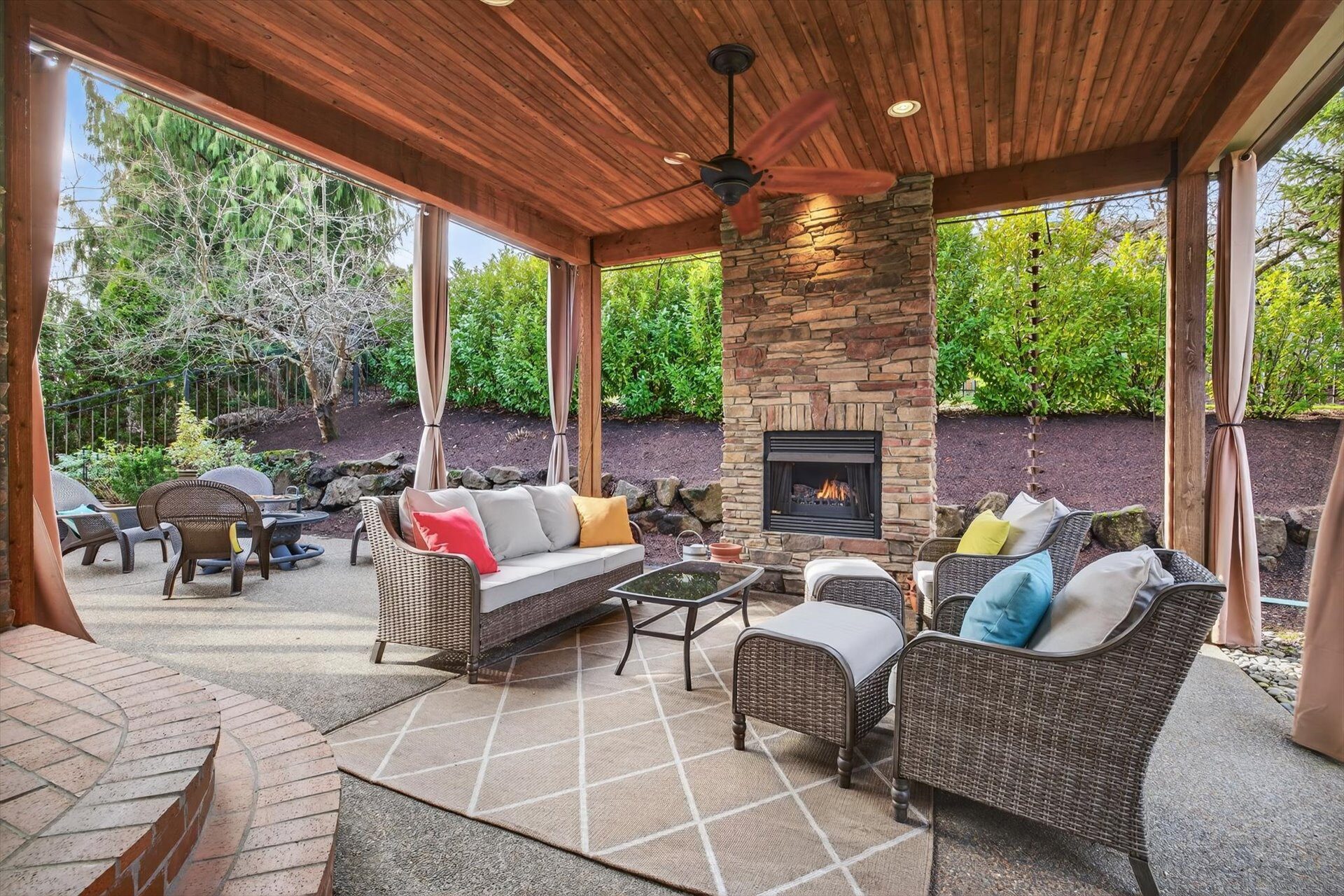 Curtain-enclosed covered outdoor living room with gas fireplace